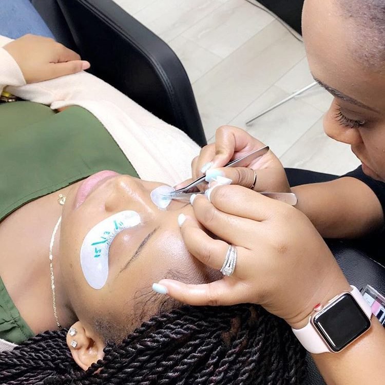 Students practicing classic and volume lash extensions on mannequins during training at Eyeconic Lashes.